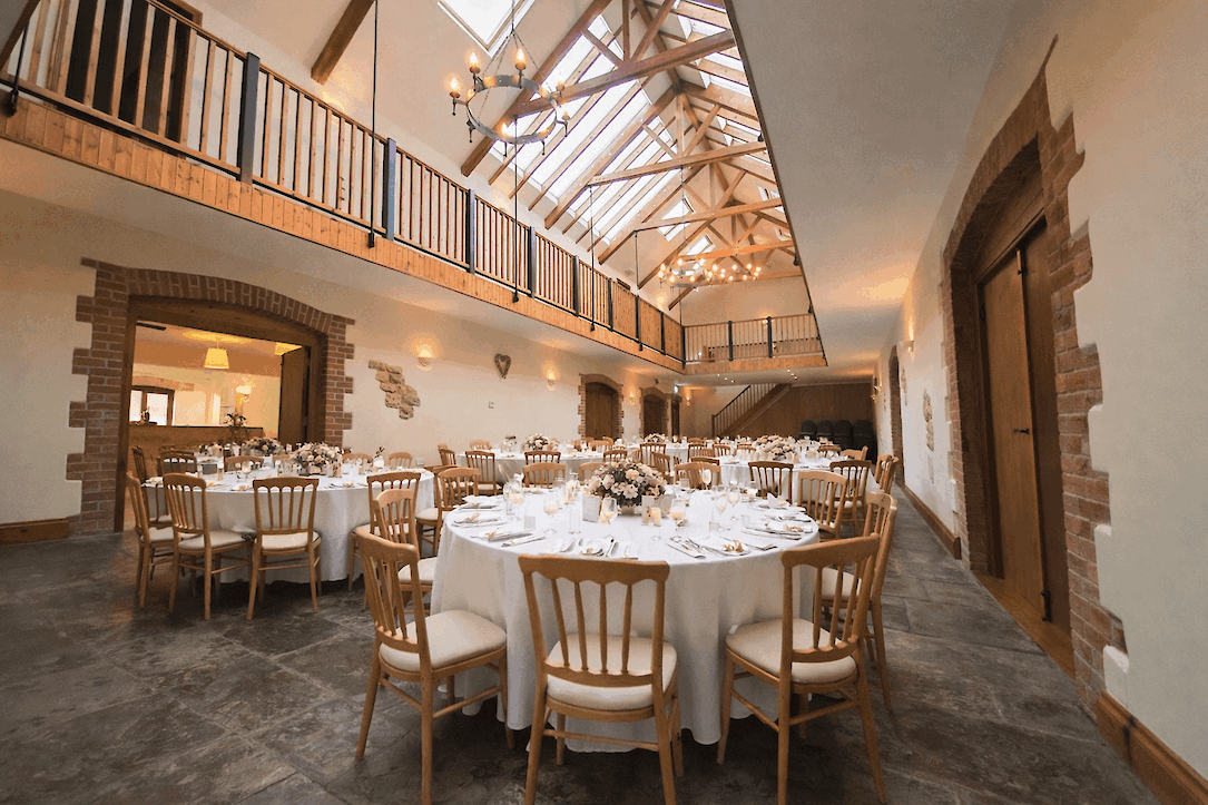 Osborne Hall set up for a group celebration with round dining tables inside The Victorian Barn Dorset.