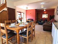 The open plan kitchen and lounge. Cosy sofas with throws and cushions.