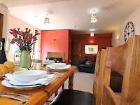 The open plan kitchen and lounge. Cosy sofas with throws and cushions.