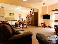 The open plan kitchen and lounge. Cosy sofas with throws and cushions.