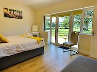 King or Twin ensuite bedroom with patio doors opening onto the patio with private hot tub and garden furniture