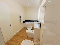 Sleek bathroom showing Bath tub, Sink, Toilet, heated towel rail and underfloor heating.